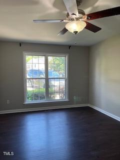 unfurnished room featuring dark wood-type flooring and ceiling fan