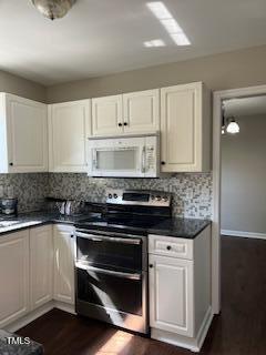 kitchen with range with two ovens, tasteful backsplash, dark wood-type flooring, and white cabinets