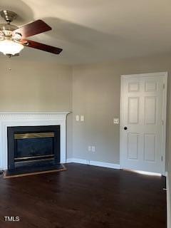 unfurnished living room featuring ceiling fan and dark hardwood / wood-style flooring