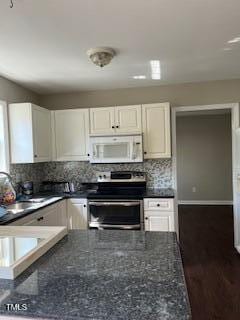 kitchen with white cabinetry, electric range, tasteful backsplash, and dark stone counters