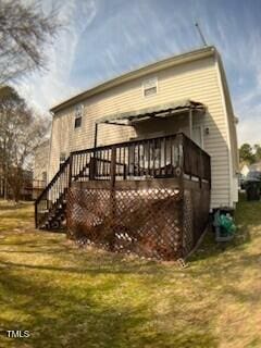 rear view of property with a deck, a yard, and stairs