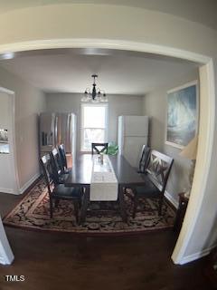 dining room featuring a chandelier, baseboards, and wood finished floors