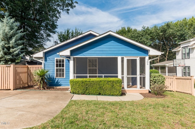 rear view of property with a sunroom and a yard