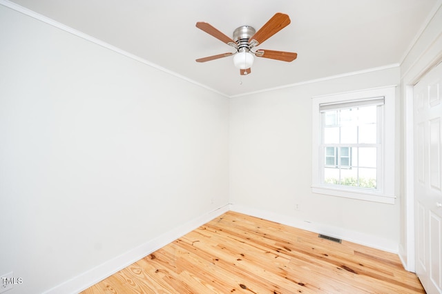 empty room featuring ceiling fan, hardwood / wood-style floors, and crown molding