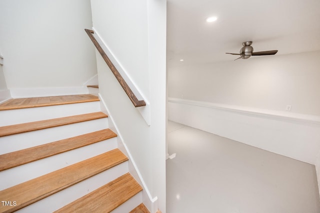 stairway featuring ceiling fan