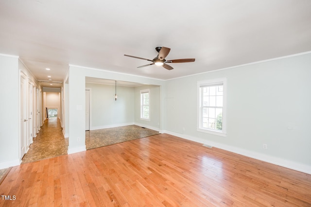 empty room with ceiling fan, crown molding, and light hardwood / wood-style flooring