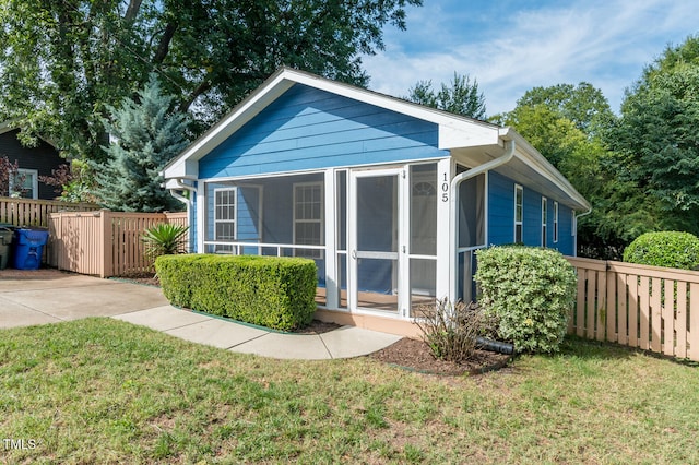 rear view of property with a sunroom and a yard