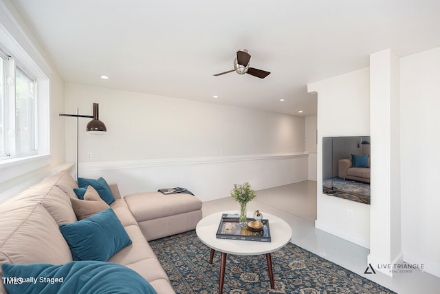 living room featuring ceiling fan and concrete floors