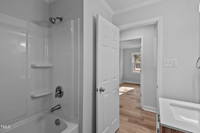 bathroom with vanity, washtub / shower combination, wood-type flooring, crown molding, and a textured ceiling