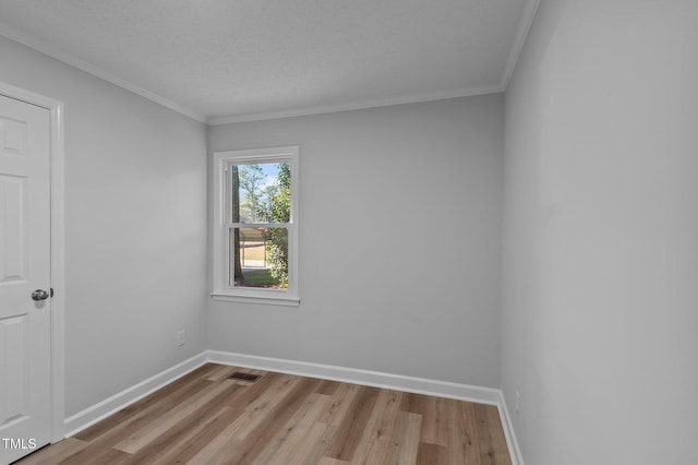 empty room featuring light hardwood / wood-style floors, a textured ceiling, and ornamental molding