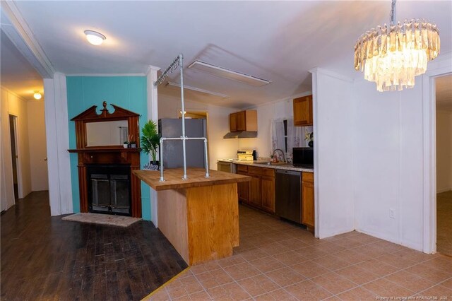 kitchen featuring stainless steel appliances, ornamental molding, a chandelier, and hanging light fixtures