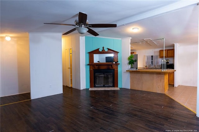 unfurnished living room with ceiling fan, hardwood / wood-style flooring, and beamed ceiling