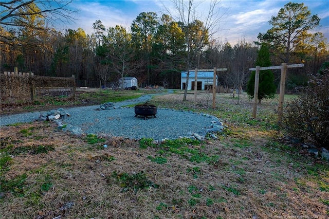 view of yard featuring an outdoor fire pit and a shed