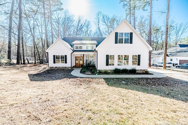 modern farmhouse style home with a front lawn