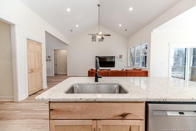 kitchen featuring stainless steel dishwasher, light hardwood / wood-style flooring, light brown cabinetry, lofted ceiling, and sink