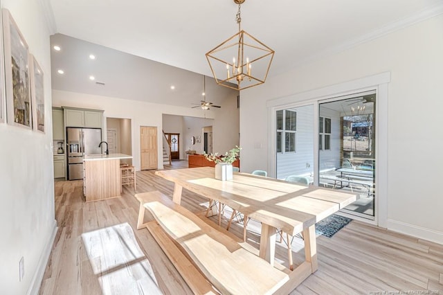 dining space featuring ceiling fan with notable chandelier and light wood-type flooring