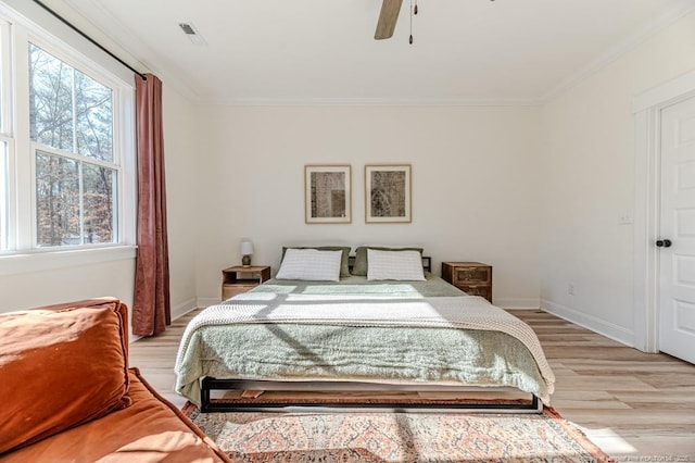 bedroom featuring ornamental molding, light wood-type flooring, and ceiling fan