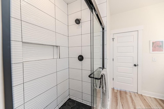 bathroom with wood-type flooring and tiled shower