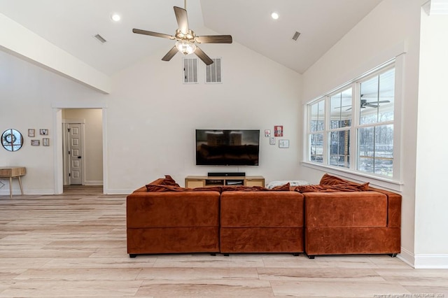 living room with ceiling fan, high vaulted ceiling, light wood-type flooring, and a wealth of natural light