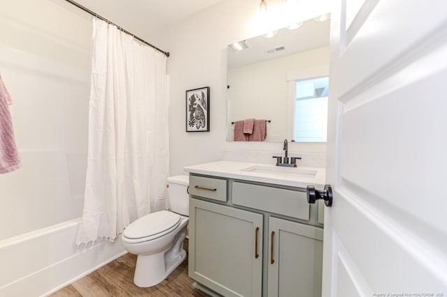 full bathroom with toilet, hardwood / wood-style flooring, shower / tub combo, and vanity