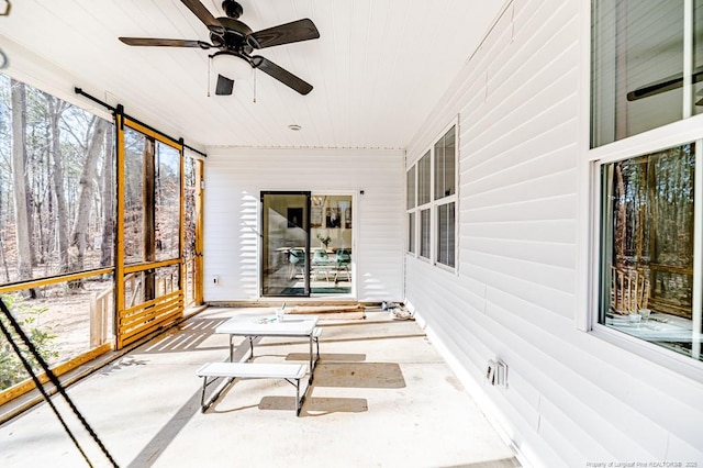 unfurnished sunroom featuring ceiling fan