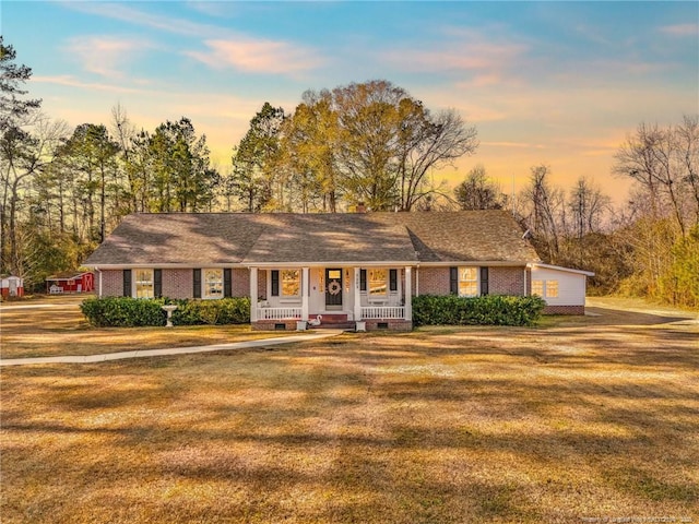 single story home with a porch and a lawn