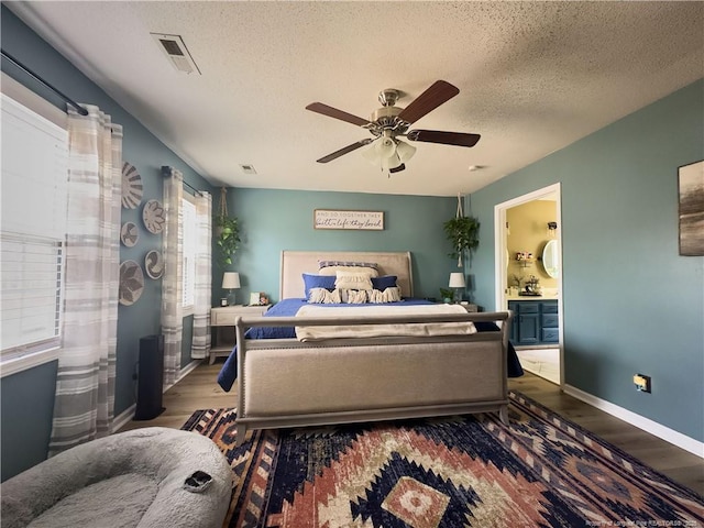 bedroom featuring ensuite bathroom, a textured ceiling, ceiling fan, and dark hardwood / wood-style flooring