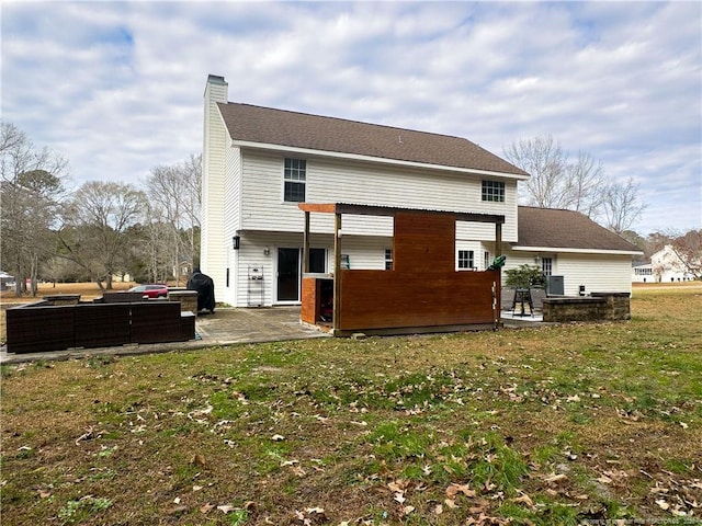 rear view of property with a lawn, outdoor lounge area, and a patio