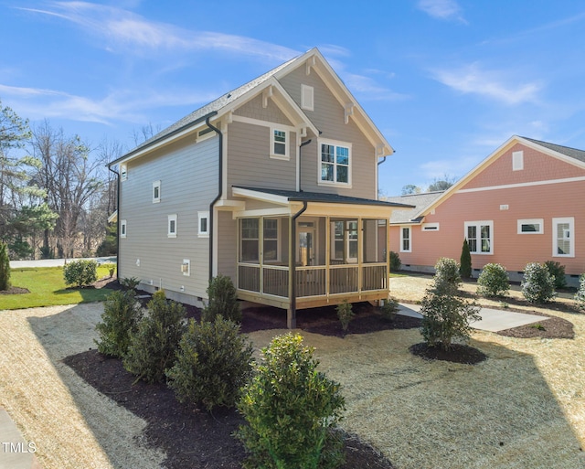 rear view of property featuring a sunroom