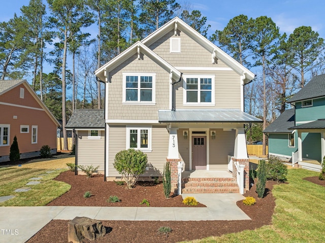 craftsman house featuring a porch, a front lawn, and driveway