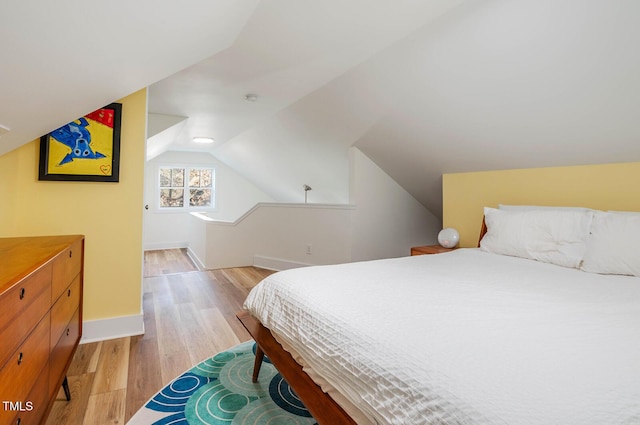 bedroom with lofted ceiling and light hardwood / wood-style floors