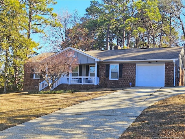 single story home featuring a porch, a front yard, and a garage