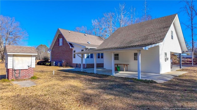 back of property with a yard and a patio area