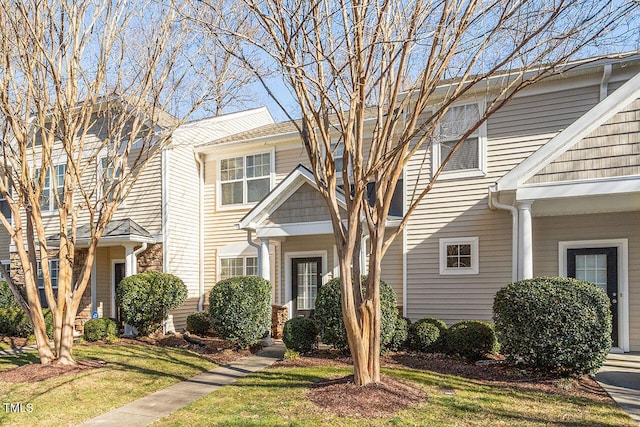 townhome / multi-family property featuring a front lawn