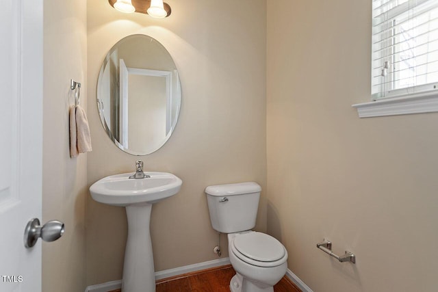 bathroom with toilet, wood-type flooring, and sink