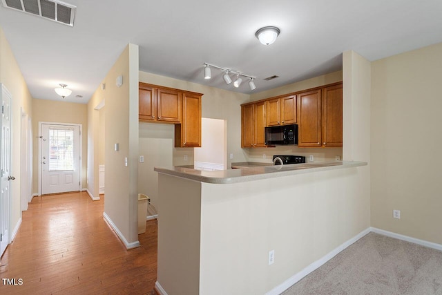 kitchen featuring light hardwood / wood-style floors, kitchen peninsula, and stove