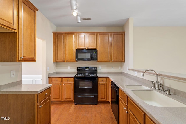 kitchen with track lighting, sink, light hardwood / wood-style flooring, and black appliances