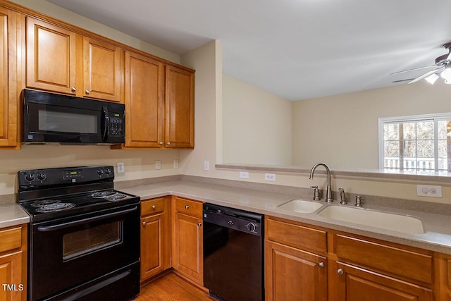 kitchen featuring light hardwood / wood-style floors, sink, black appliances, and ceiling fan