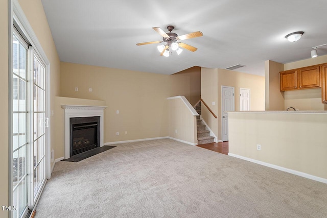 unfurnished living room with ceiling fan and dark carpet