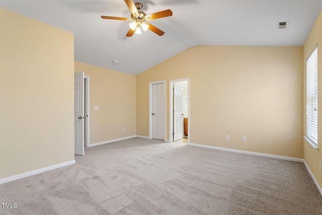 carpeted empty room with ceiling fan and vaulted ceiling