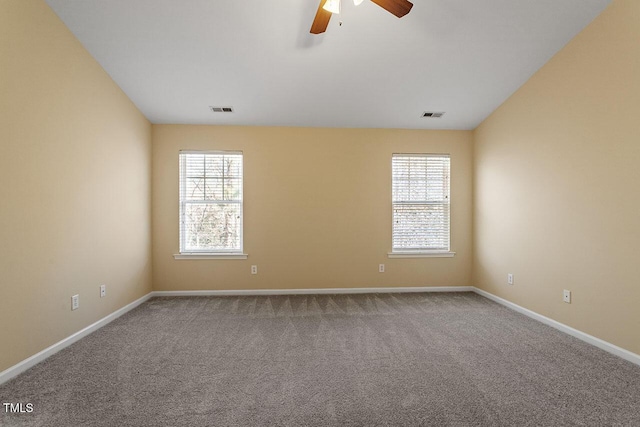 carpeted empty room featuring ceiling fan and a wealth of natural light