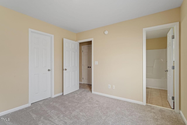 unfurnished bedroom with light carpet and ensuite bath