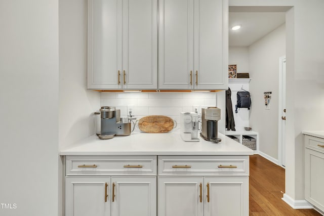 kitchen featuring light wood-type flooring, white cabinetry, and decorative backsplash