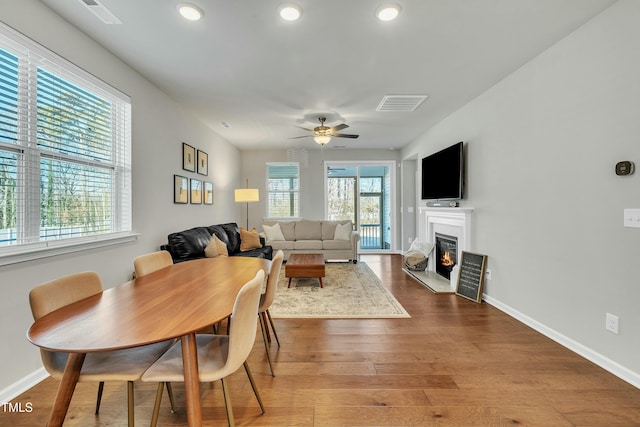 dining space with ceiling fan, a healthy amount of sunlight, and hardwood / wood-style floors