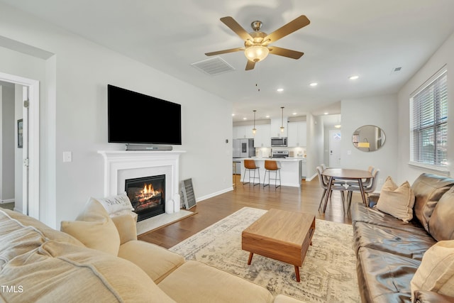 living room featuring ceiling fan and wood-type flooring