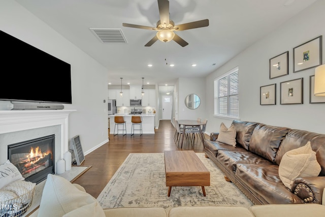 living room with ceiling fan and dark hardwood / wood-style floors