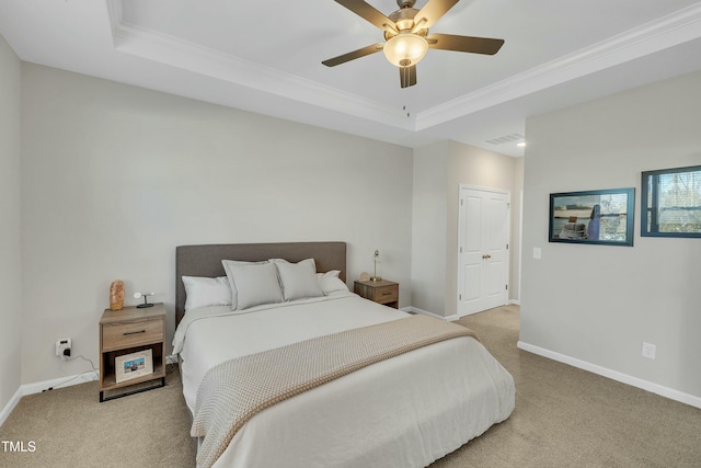 bedroom with ceiling fan, light colored carpet, and a tray ceiling