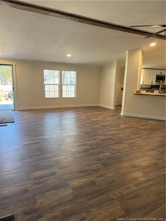 unfurnished living room featuring ceiling fan and dark hardwood / wood-style floors