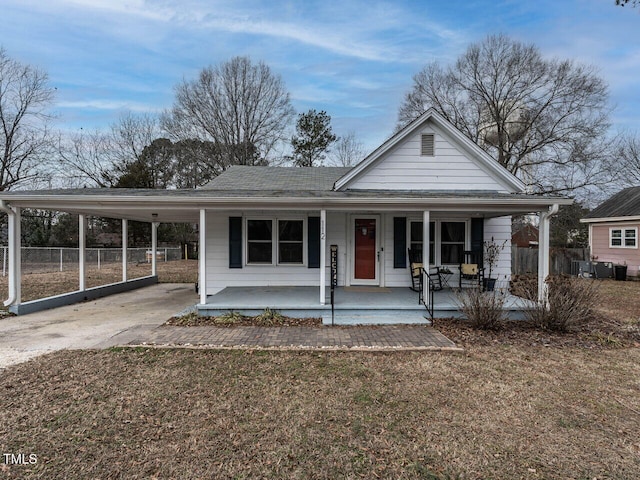 farmhouse with a carport, covered porch, and a front yard