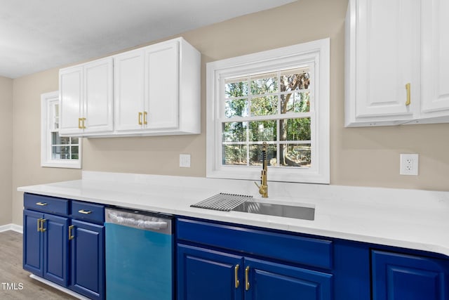 kitchen with sink, blue cabinetry, dishwasher, white cabinetry, and light hardwood / wood-style floors